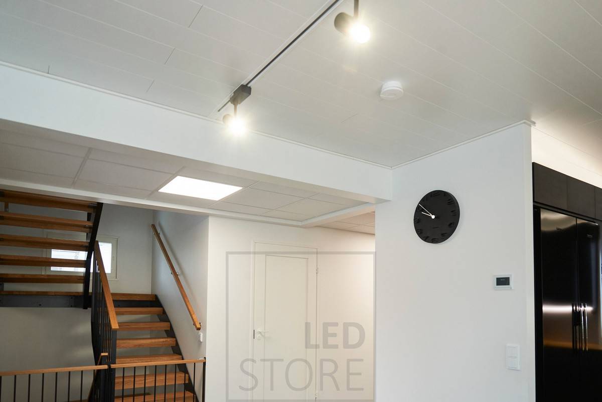 Černá ledková světla osvětlující obývací pokoj, panelové světlo v chodbě připomínající střešní okno. Ledstore.fi